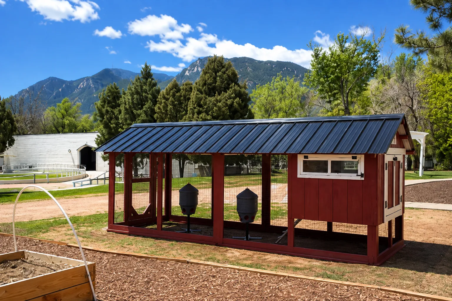 The covered run and feeders on the school's new coop, mountains behind