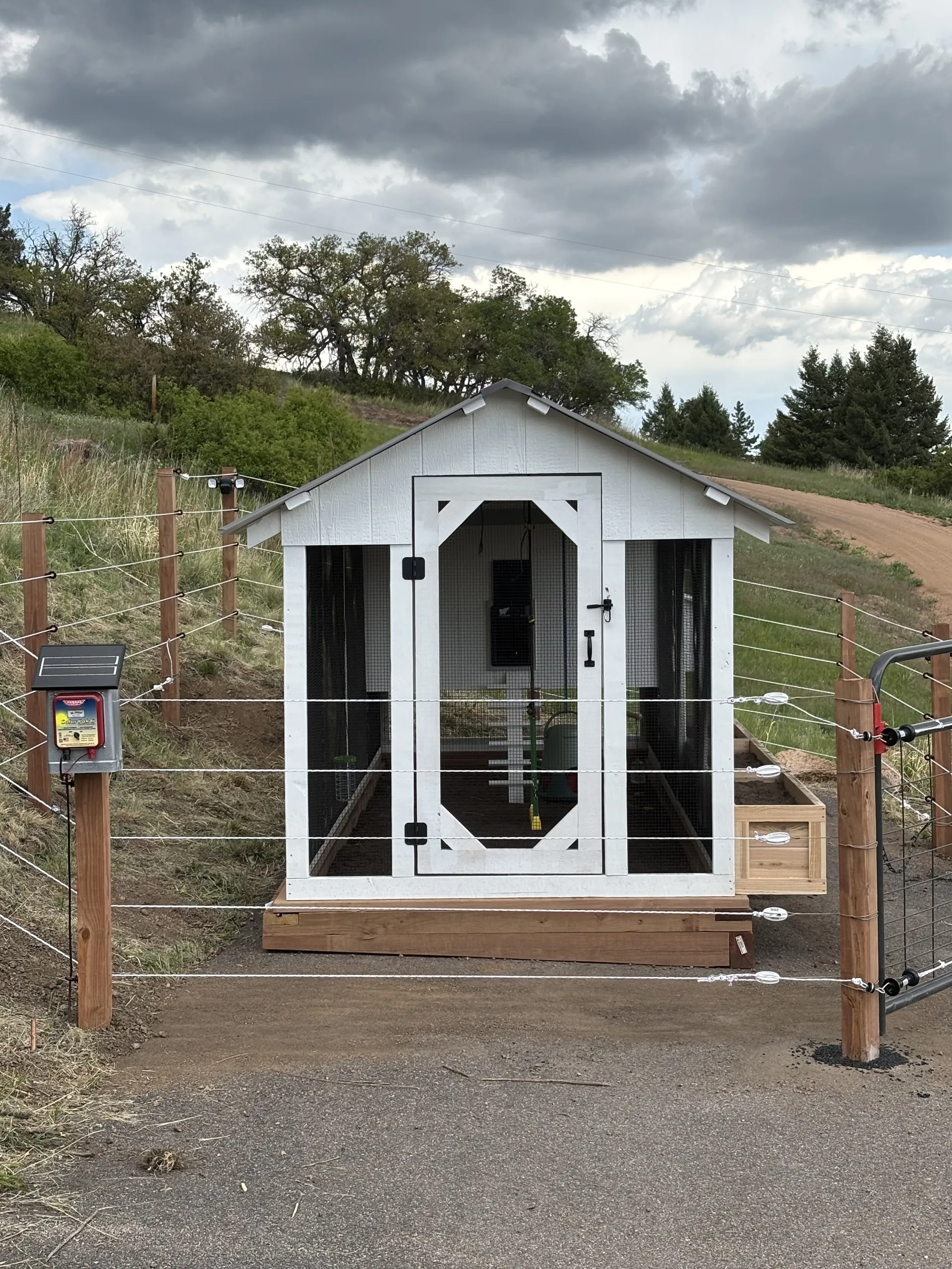 A LuckyBird Barn House Coop behind a five-strand solar electric fence in Larkspur, Colorado