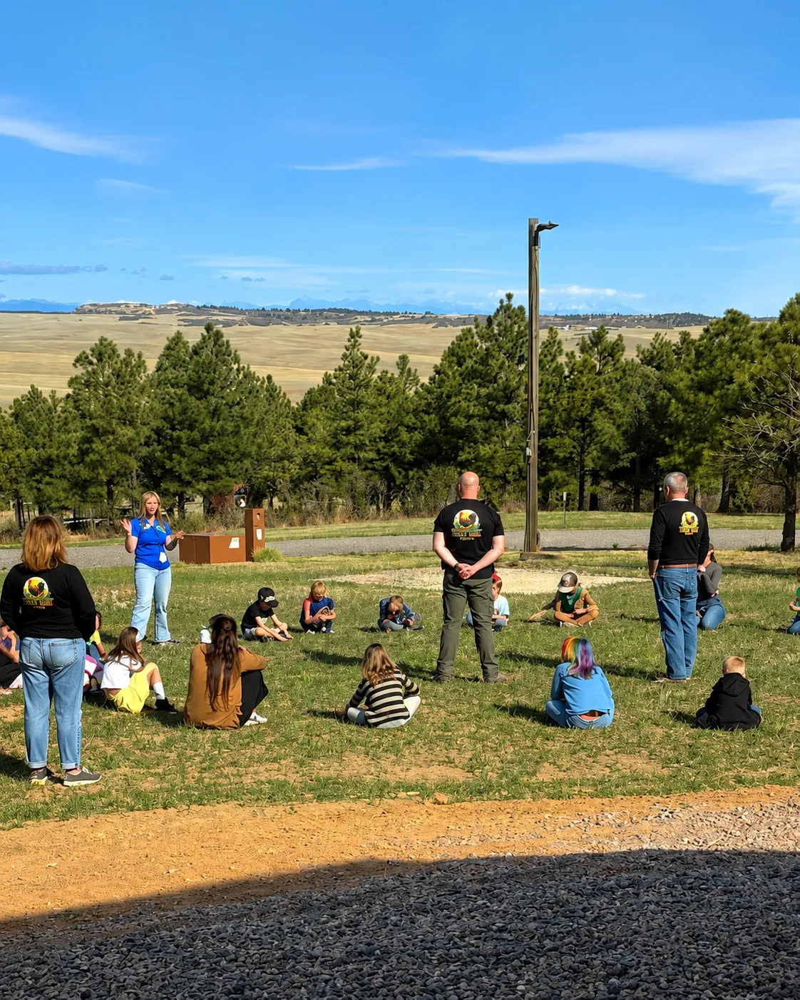 The LuckyBird team talking with the class on the grass at the farm
